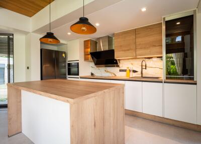 Modern kitchen with island, pendant lights, and stainless steel appliances