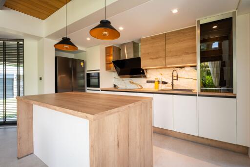 Modern kitchen with island, pendant lights, and stainless steel appliances