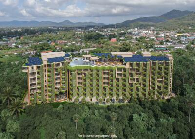 Aerial view of a modern residential building surrounded by lush greenery with a mountainous background