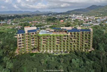 Aerial view of a modern residential building surrounded by lush greenery with a mountainous background