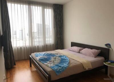 Well-lit bedroom with wooden flooring and large window