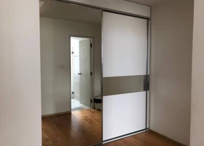 Bedroom with sliding closet doors and wooden flooring