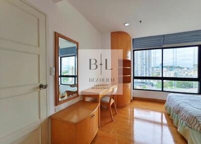 A bedroom with wooden furniture and large window