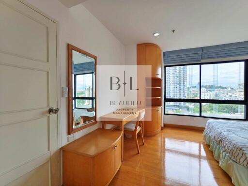 A bedroom with wooden furniture and large window