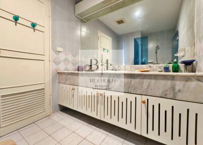 Bathroom with large vanity mirror and built-in cabinets