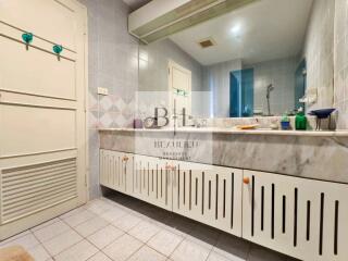 Bathroom with large vanity mirror and built-in cabinets