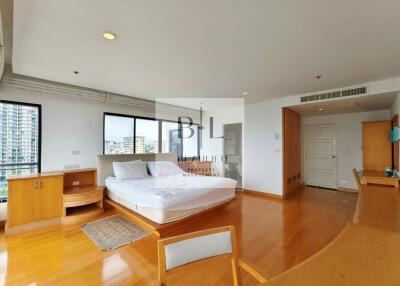 Spacious bedroom with large windows and wooden floor