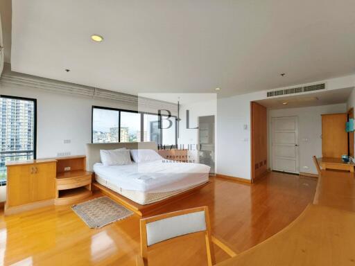 Spacious bedroom with large windows and wooden floor