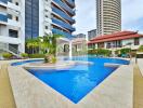 Outdoor swimming pool area with buildings in the background