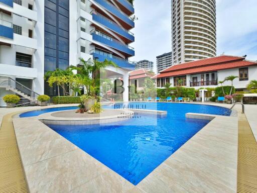 Outdoor swimming pool area with buildings in the background