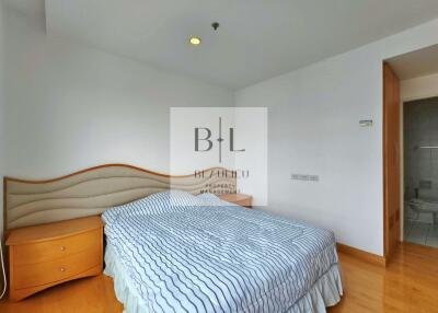 Bedroom with bed, nightstands, and wooden flooring