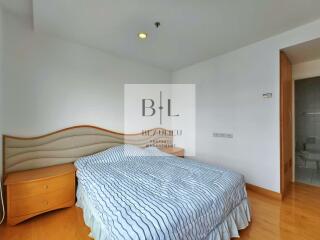 Bedroom with bed, nightstands, and wooden flooring