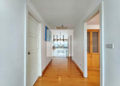 Spacious hallway with wooden flooring and white walls