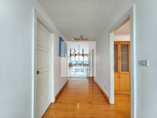 Spacious hallway with wooden flooring and white walls