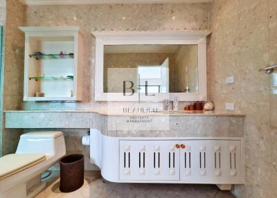 modern bathroom with vanity, toilet, and large mirror