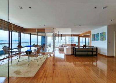 Spacious living room with wooden flooring and large windows offering a scenic view