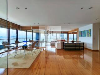 Spacious living room with wooden flooring and large windows offering a scenic view