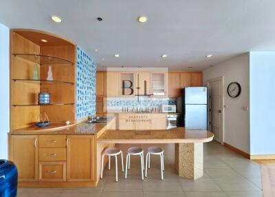 Modern kitchen with wooden cabinetry and bar seating