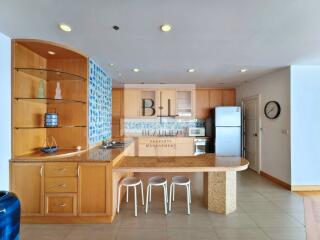 Modern kitchen with wooden cabinetry and bar seating