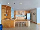 Modern kitchen with wooden cabinetry and bar seating