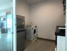 Laundry room with washing machine and refrigerator