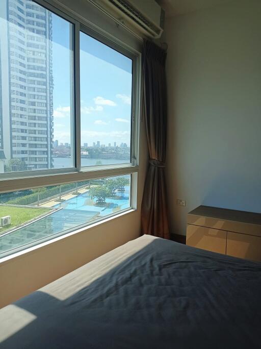 Bedroom with large window and city view