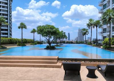 Outdoor pool area with a view of the city and modern high-rise buildings