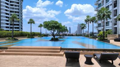 Outdoor pool area with a view of the city and modern high-rise buildings