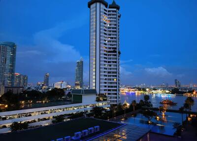 Scenic night view of a high-rise building by the river with city lights