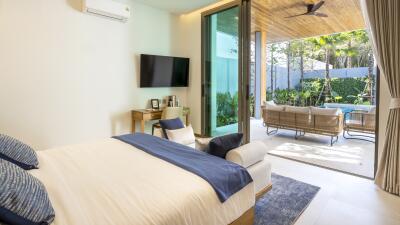 Modern bedroom with large sliding glass doors leading to a patio with a pool