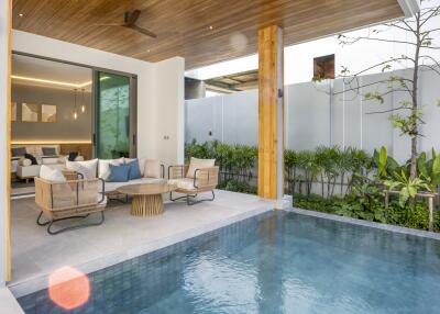 Outdoor seating area next to private pool with view into living room