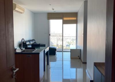 Living room with kitchen area and large windows