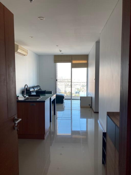 Living room with kitchen area and large windows