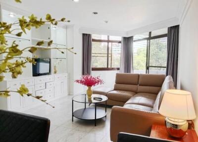 Cozy living room with a large window, a sectional sofa, and a TV unit