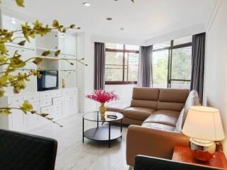 Cozy living room with a large window, a sectional sofa, and a TV unit