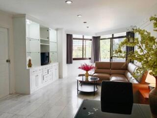 Bright and spacious living room with a brown leather sectional sofa and modern decor