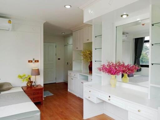 Spacious bedroom with vanity area and decorative flowers