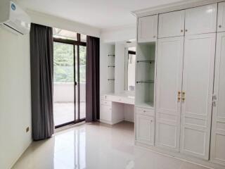 Bright bedroom with large window and built-in wardrobe