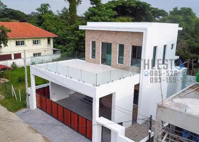 Modern two-story house with a large balcony and garage