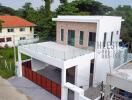 Modern two-story house with a large balcony and garage