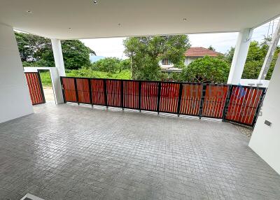 Spacious covered outdoor area with tiled flooring and a view of a well-maintained garden and neighborhood