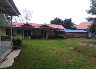 Exterior view of property with green lawn and several small houses