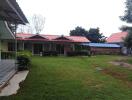 Exterior view of property with green lawn and several small houses