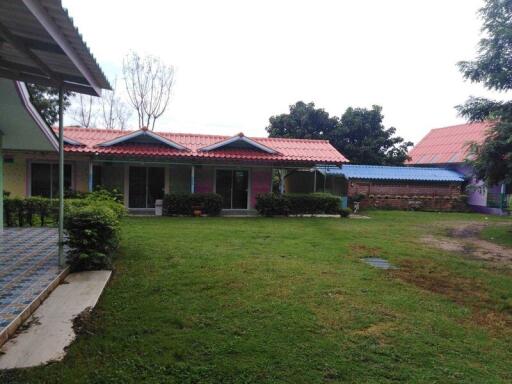 Exterior view of property with green lawn and several small houses