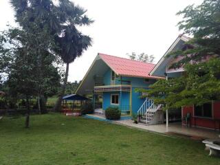 Colorful house with porch and surrounding greenery