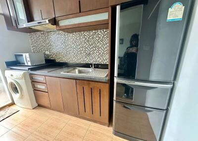 Modern kitchen with wooden cabinets, tiled backsplash, and appliances