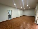 Spacious empty room with tiled floor and recessed lighting