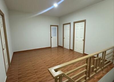 Interior view of a hallway with multiple doors and wooden staircase