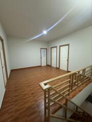 Interior view of a hallway with multiple doors and wooden staircase