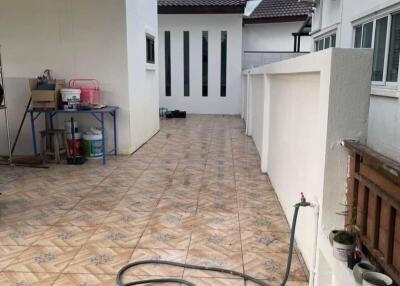 Outdoor area with tiled flooring and garden hose